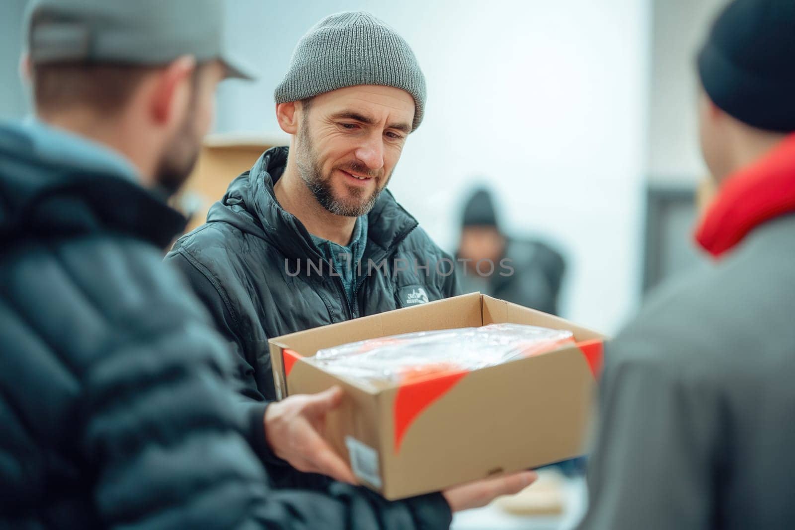 Volunteers are holding a cardboard box with clothes, donating to charity