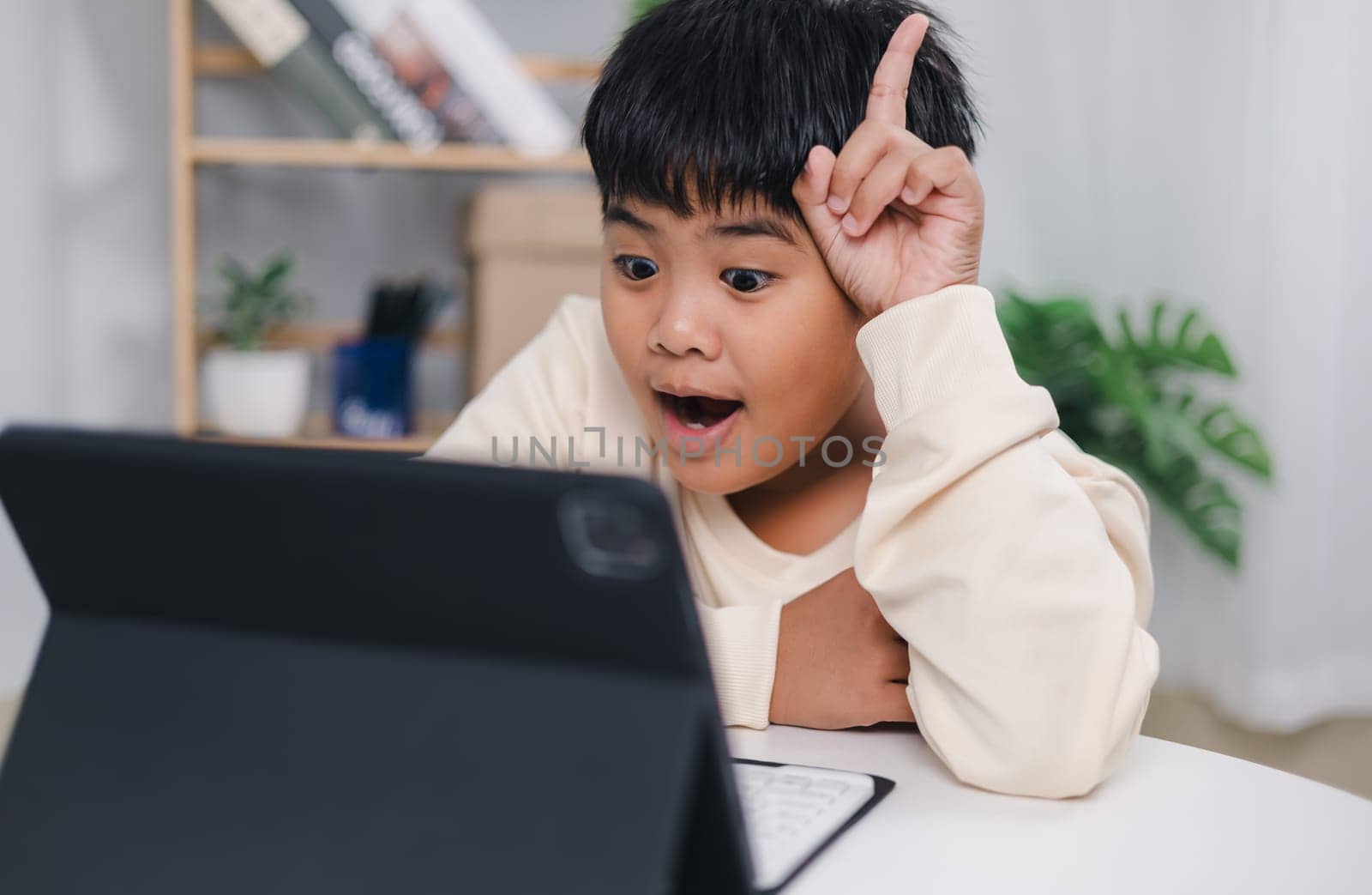 Educational of tech concept, Staying at home, Asian boy student using tablet learning. Presenting a modern educational way of life. Virtual internet online class from school teacher.