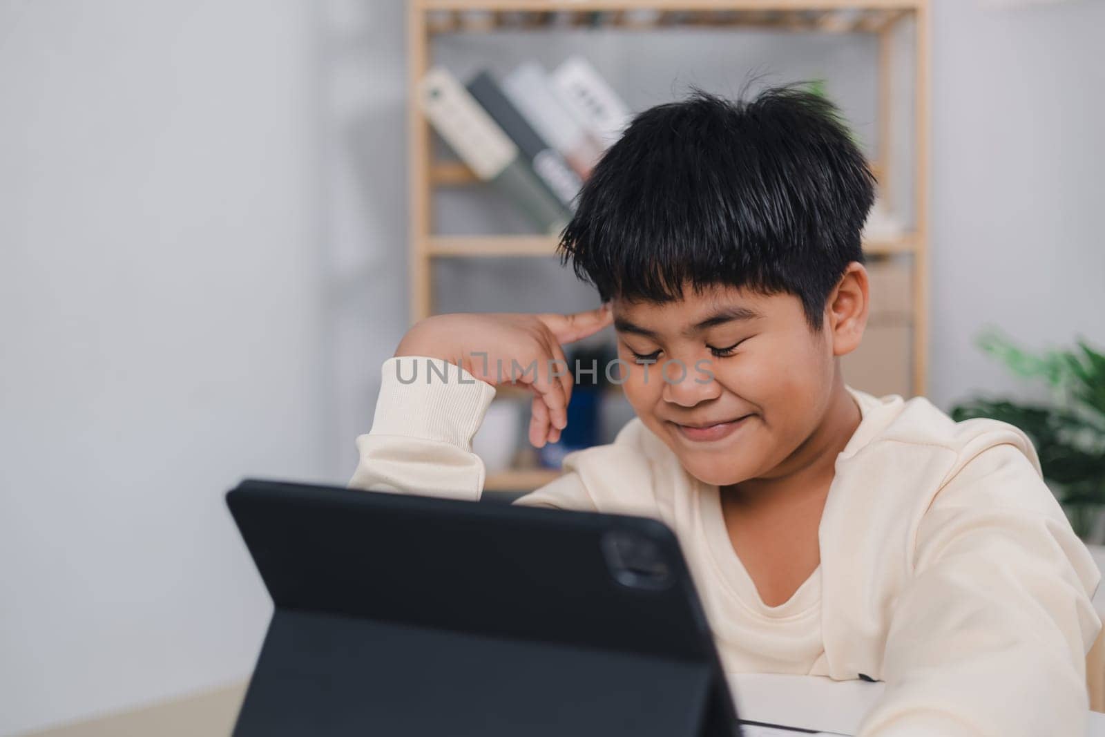 Educational of tech concept, Staying at home, Asian boy student using tablet learning. Presenting a modern educational way of life. Virtual internet online class from school teacher.