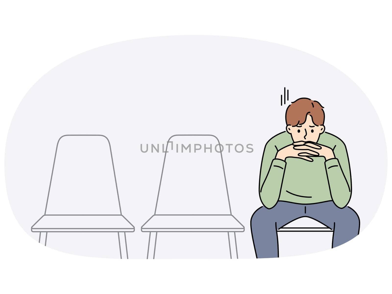 Sad man is waiting for start of interview, sitting in office corridor with empty chairs. Guy is nervous before interview because of problems in labor market and difficulty of finding well-paid job