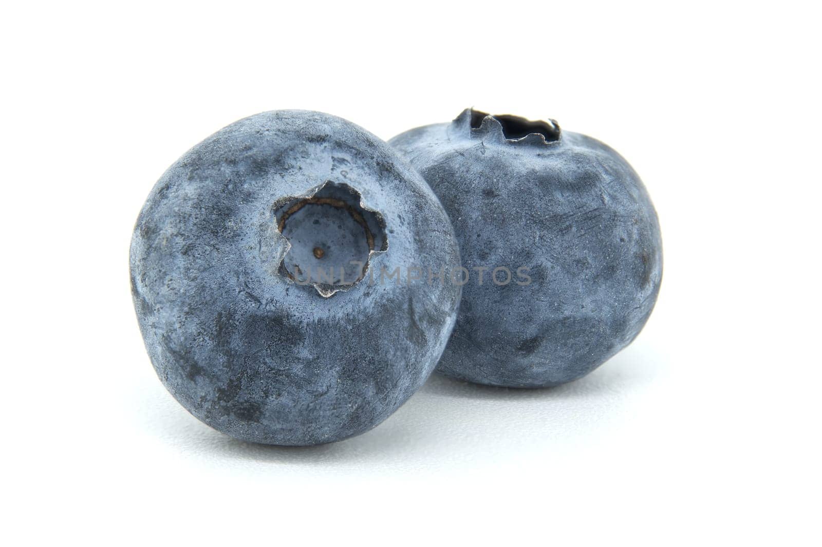 A detailed close-up of two fresh blueberries showcasing their texture and color on a clean white background. Perfect for healthy eating, nutrition, and fruit-themed designs