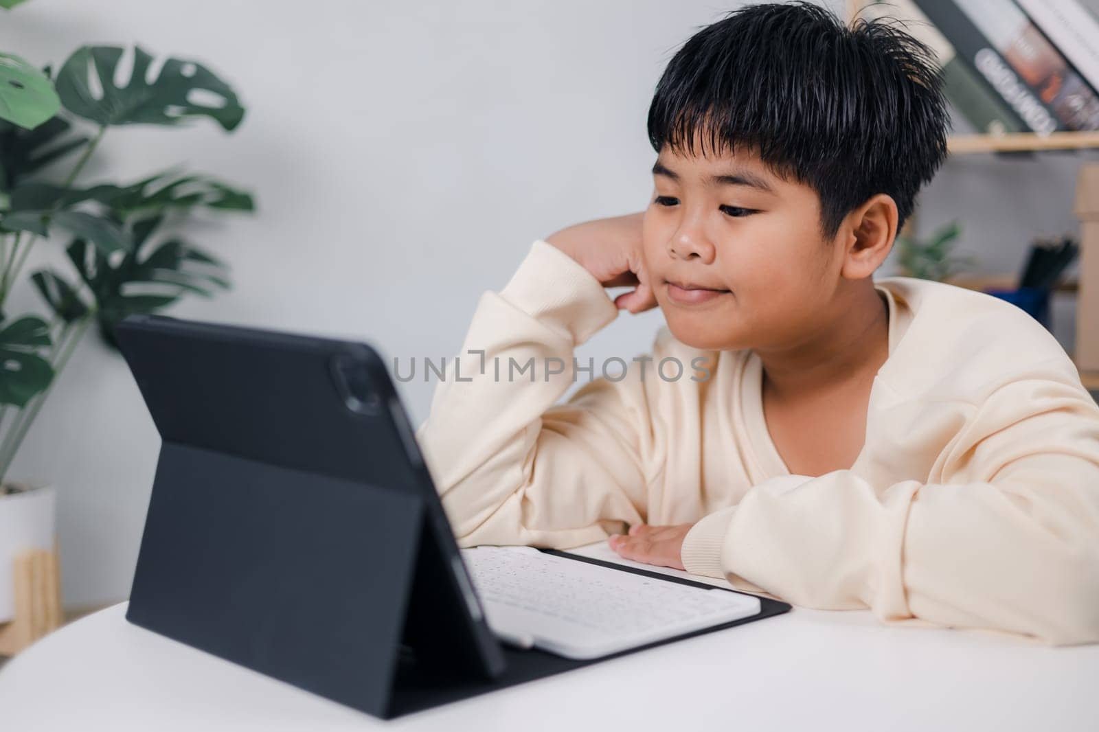 Asian boy student using tablet learning, Educational of tech concept, Staying at home, Presenting a modern educational way of life, Virtual internet online class from school teacher.