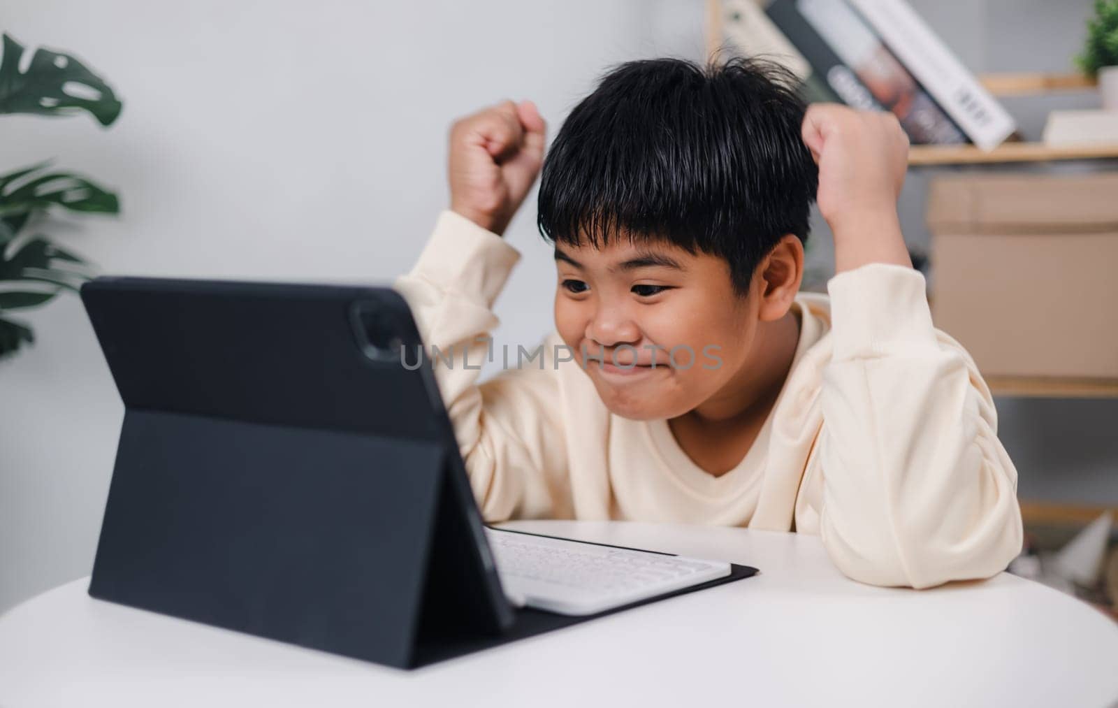 Asian boy student using tablet learning, Educational of tech concept, Staying at home, Presenting a modern educational way of life, Virtual internet online class from school teacher.