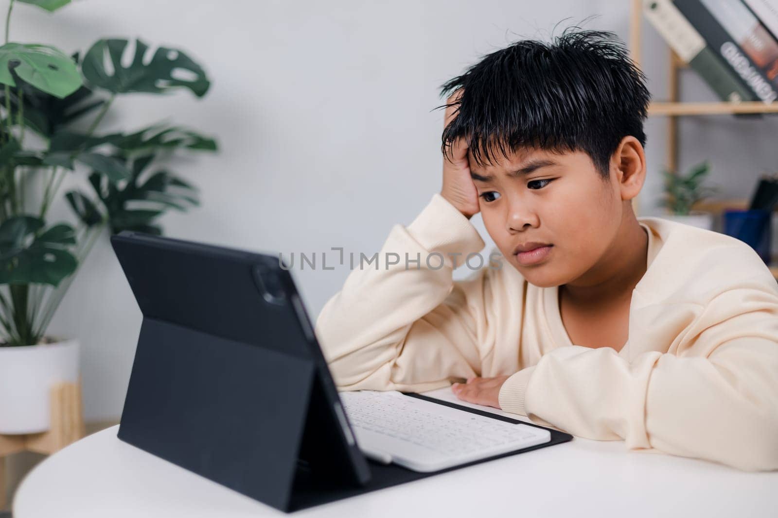 Asian boy student using tablet learning, Educational of tech concept, Staying at home, Presenting a modern educational way of life, Virtual internet online class from school teacher.