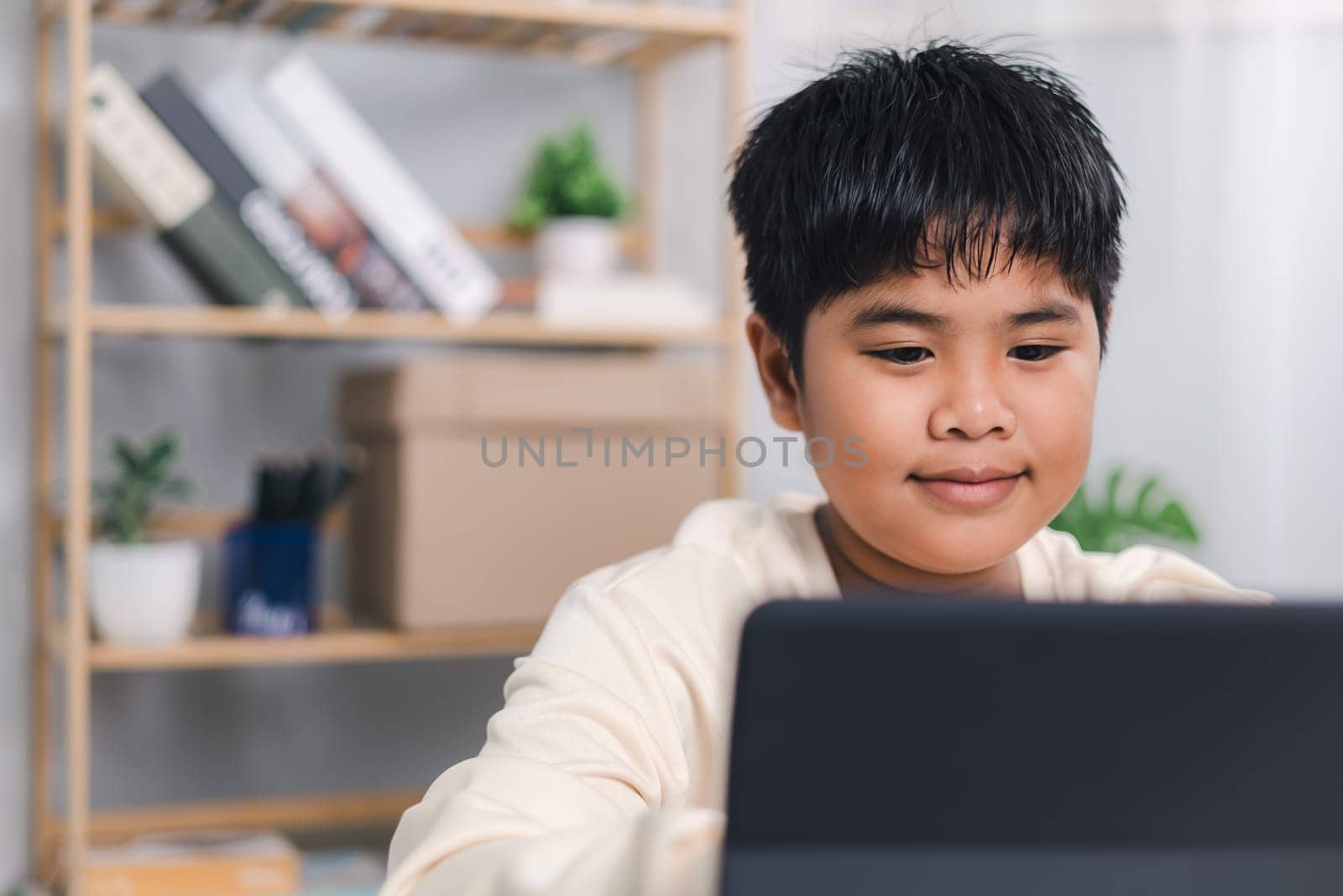 Asian boy student using tablet learning, Educational of tech concept, Staying at home, Presenting a modern educational way of life, Virtual internet online class from school teacher.