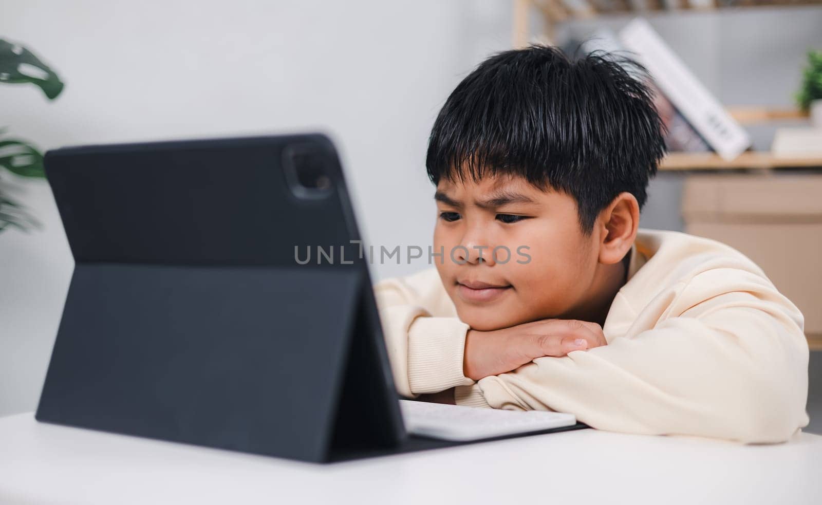 Asian boy student using tablet learning, Educational of tech concept, Staying at home, Presenting a modern educational way of life, Virtual internet online class from school teacher.