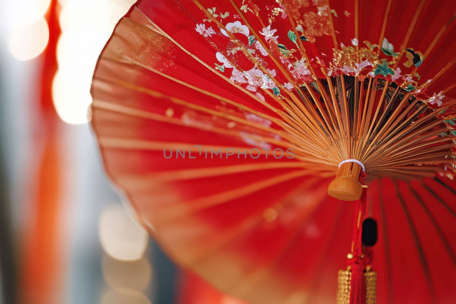 A vibrant red umbrella adorned with floral designs enhances the festive setting at a lively outdoor celebration bringing joy and color to the scene.