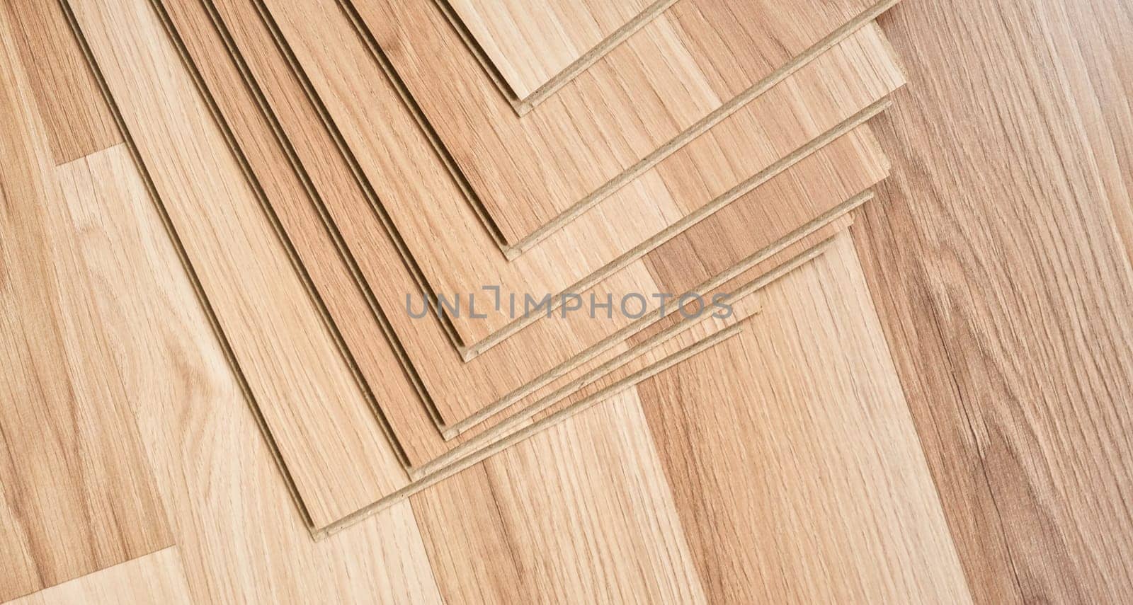 Laminated floor tiles arranged on ground, ready for installation, view from above