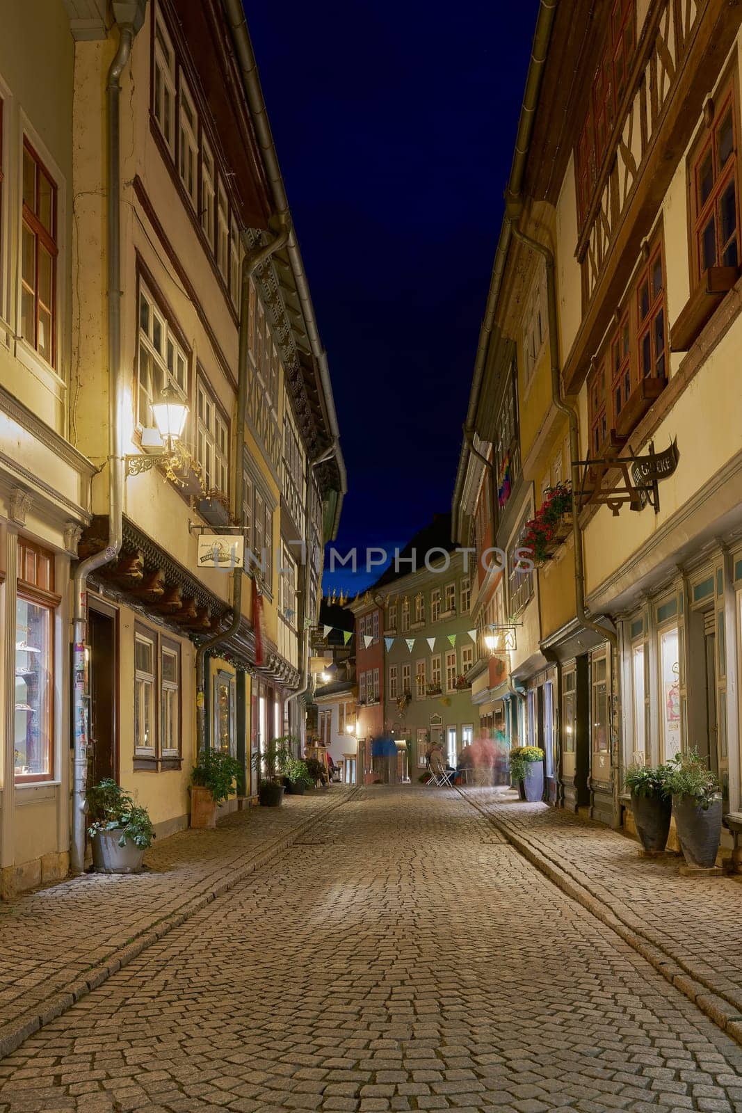 The Kraemerbruecke in Erfurt in Germany with some stores in historic houses on both sides of the bridge at night