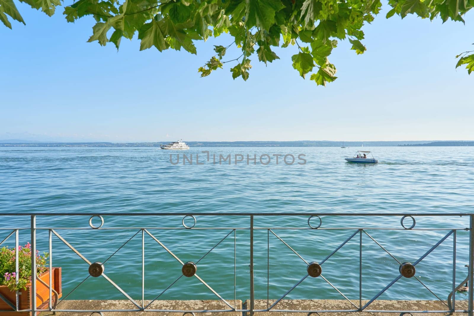 View of Lake Constance, Bodensee from the shady tree-lined promenade in Meersburg in Germany in the sunshine