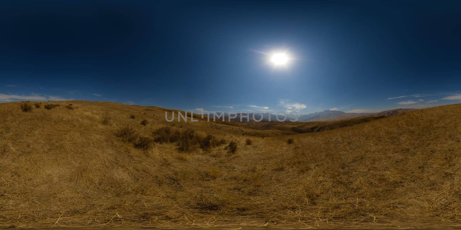 Full Spherical panorama of dry grass foothills at sunny autumn day with clear blue sky above and mountain range on the horizon, equirectangular projection