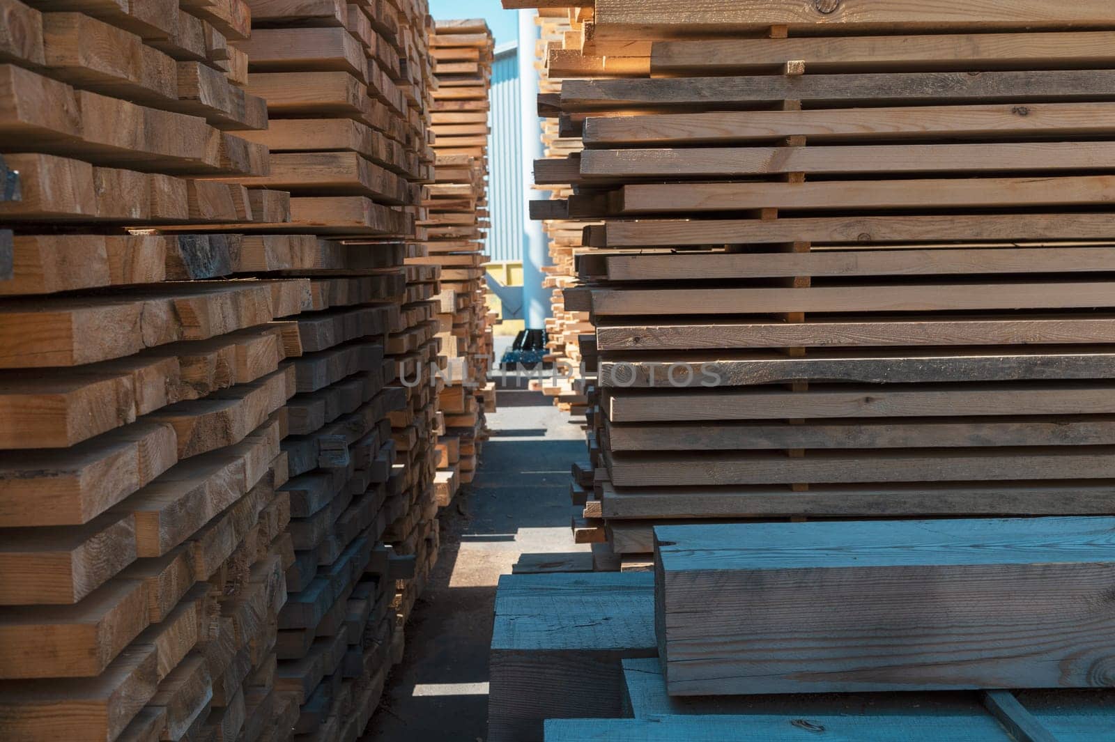 Stacked wooden planks close-up at lumber warehouse. Wood industry concept