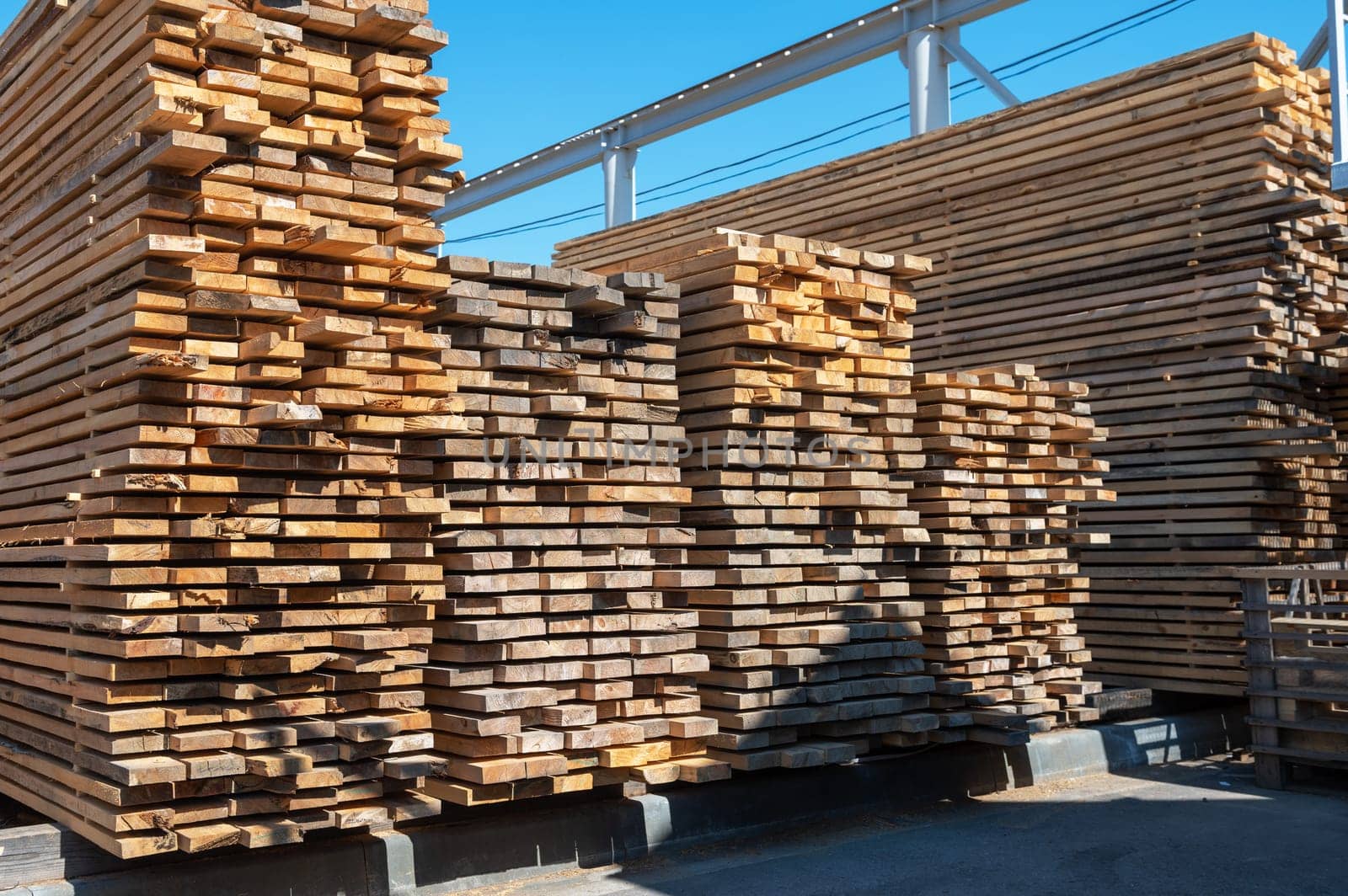 Stacked wooden planks close-up at lumber warehouse. Wood industry concept