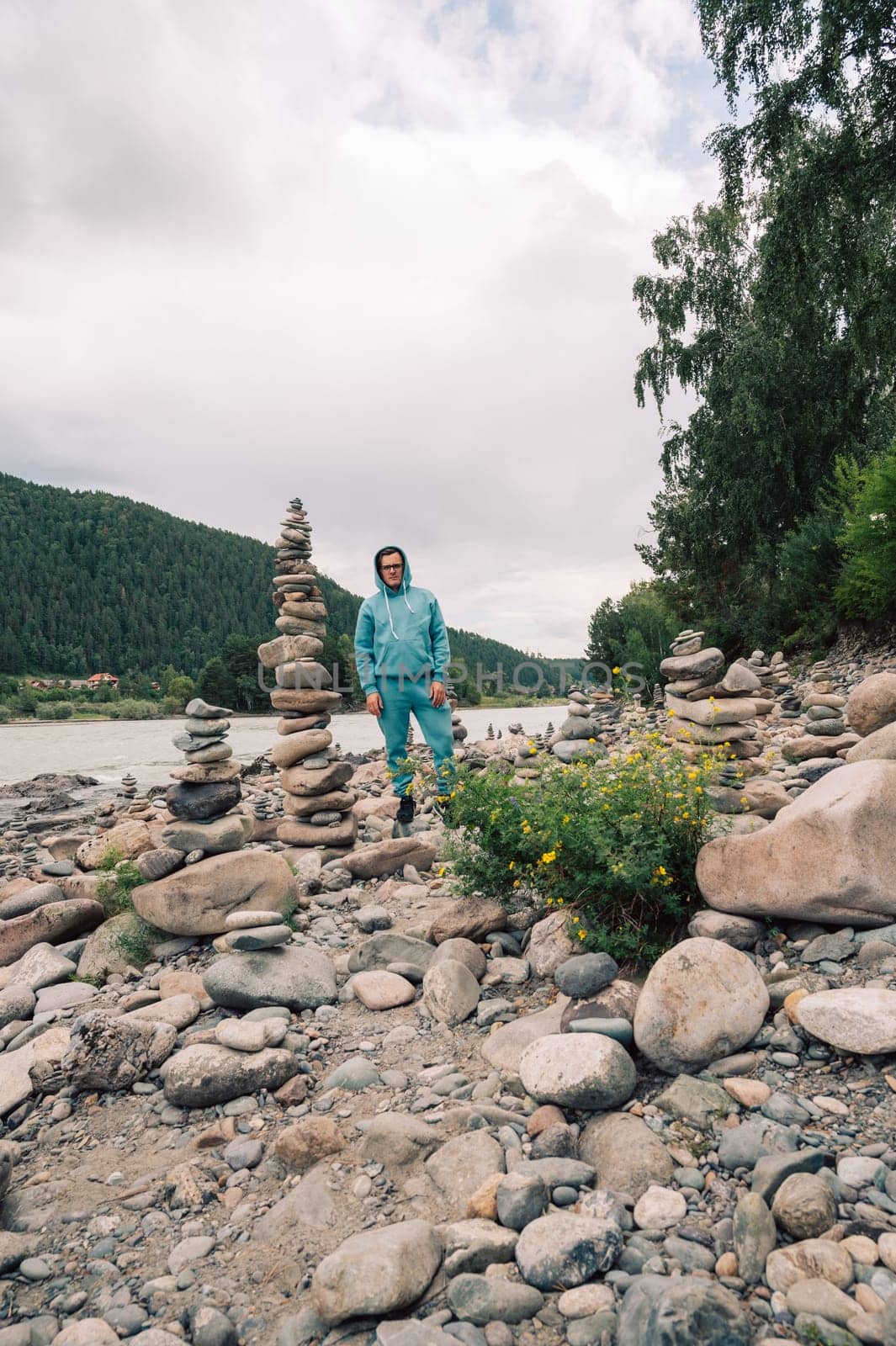 Man at the river Katun at summer day. Trip on Altai Mountains in Altai Republic