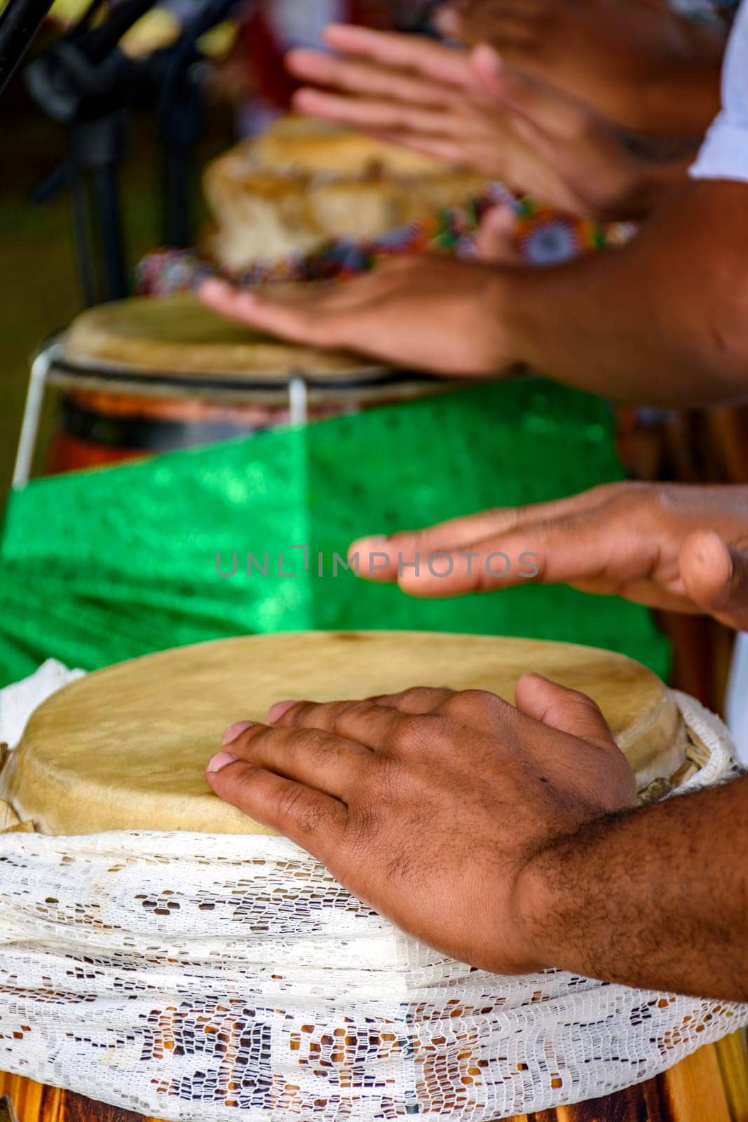 Several atabaque drums decorated with fabric being used during an Umbanda religious ceremony in Brazil