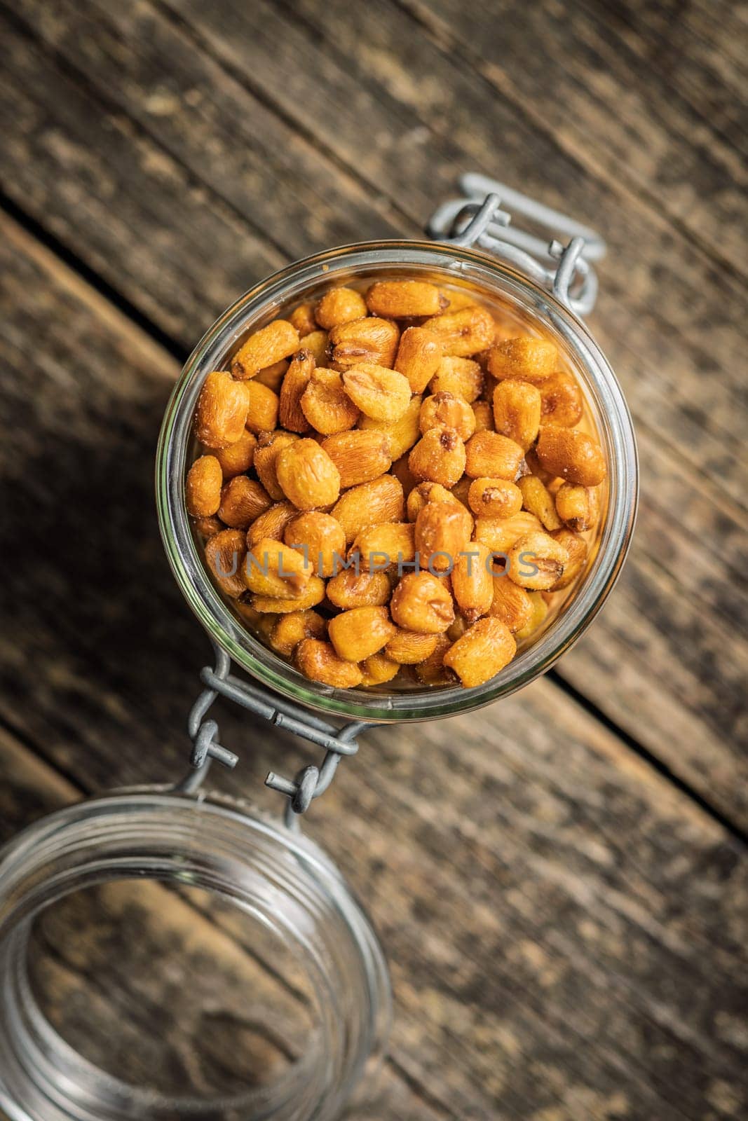 Roasted salted corn snack in jar on a wooden table. Top view.