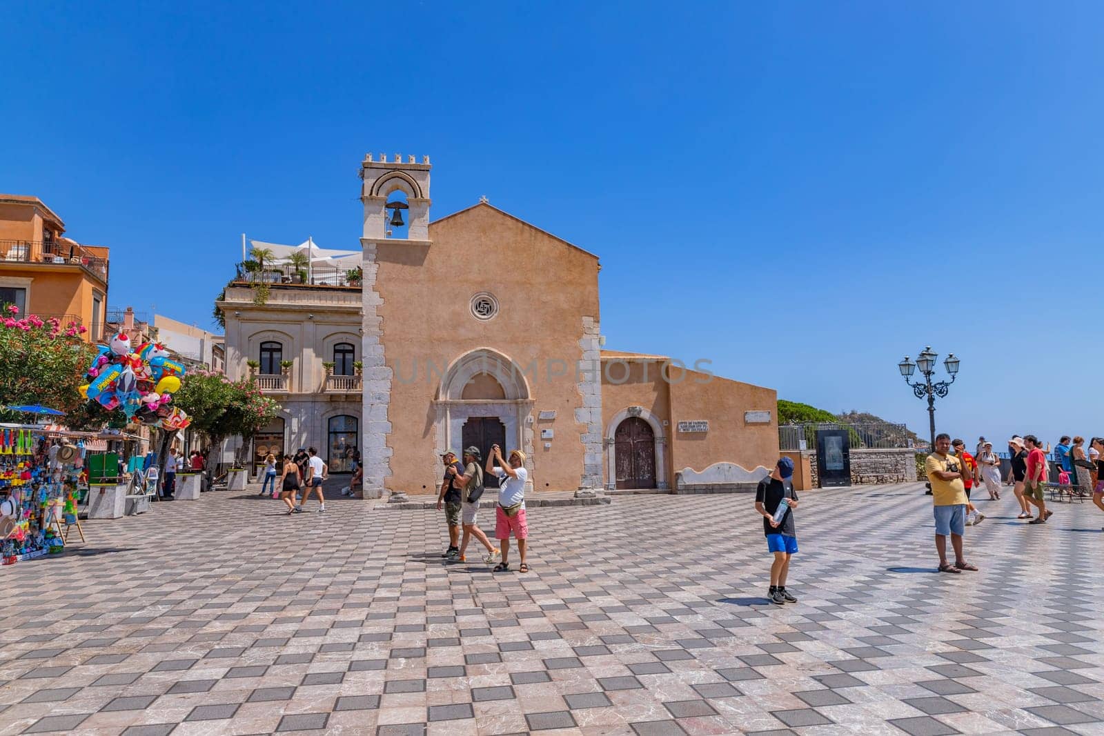 Taormina, Sicily, Italy: August 11, 2024: Cityscape image of picturesque town of Taormina, Sicily with main square Piazza IX Aprile and San Giuseppe church