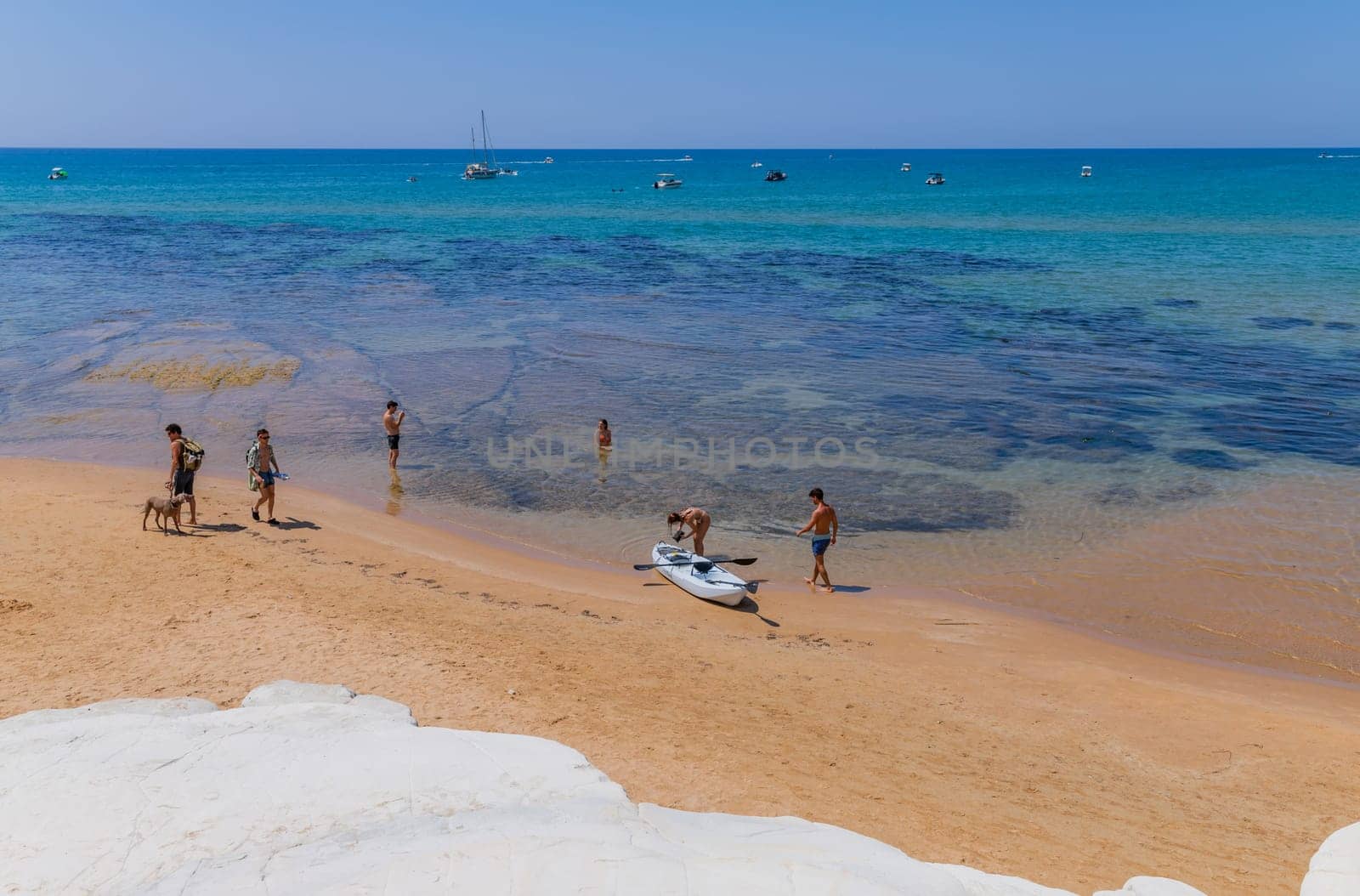 Sicily, Italy: August 9, 2024: Some people at the Beach of Scala dei Turchi (Stair of the Turks) in Sicily, Italy