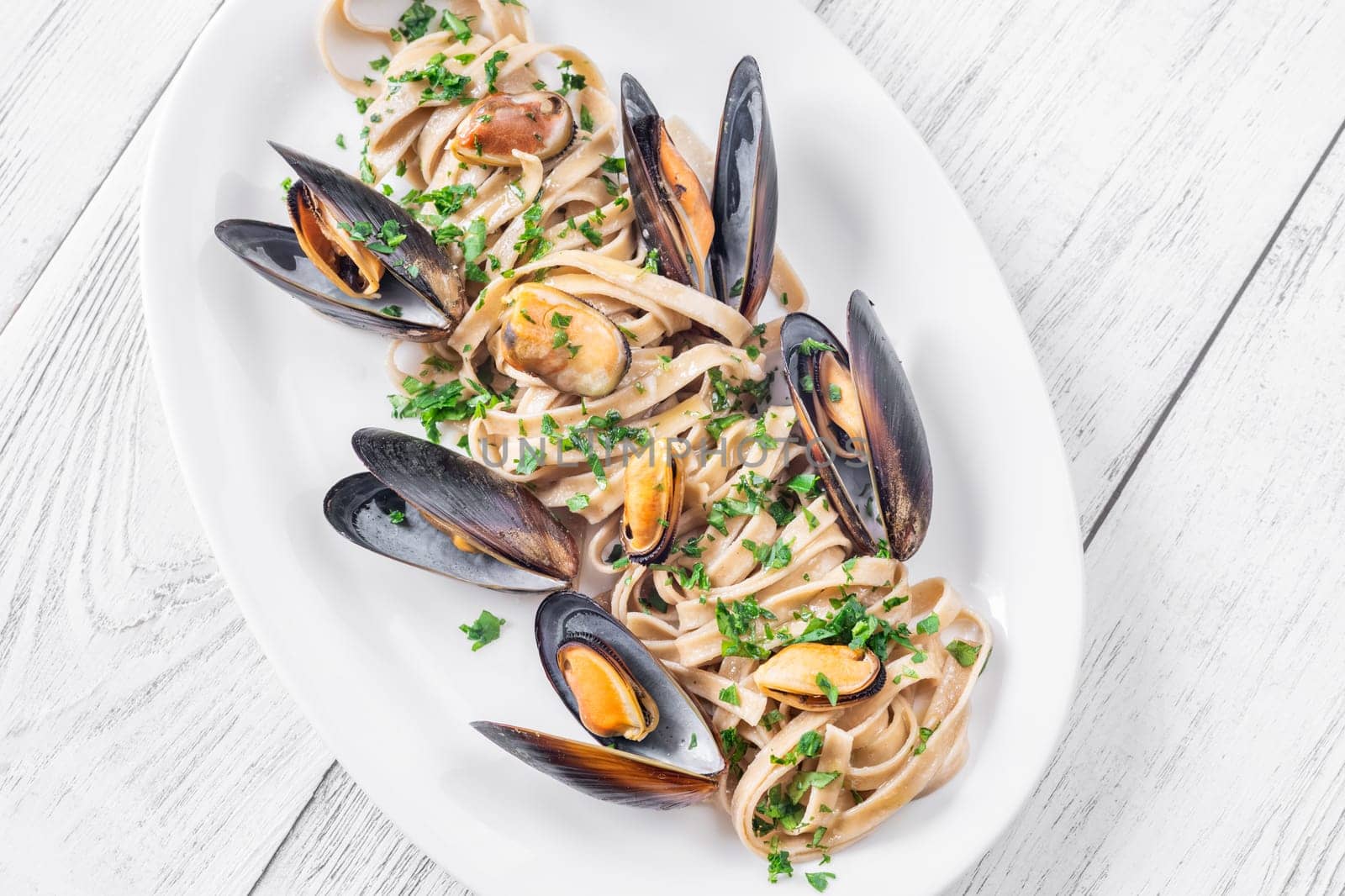 A plate of creamy fettuccine with fresh mussels