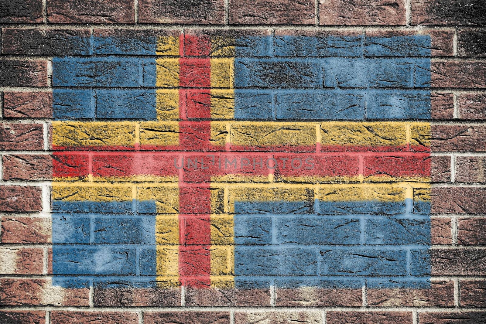 An Aland Islands flag on a brick wall background