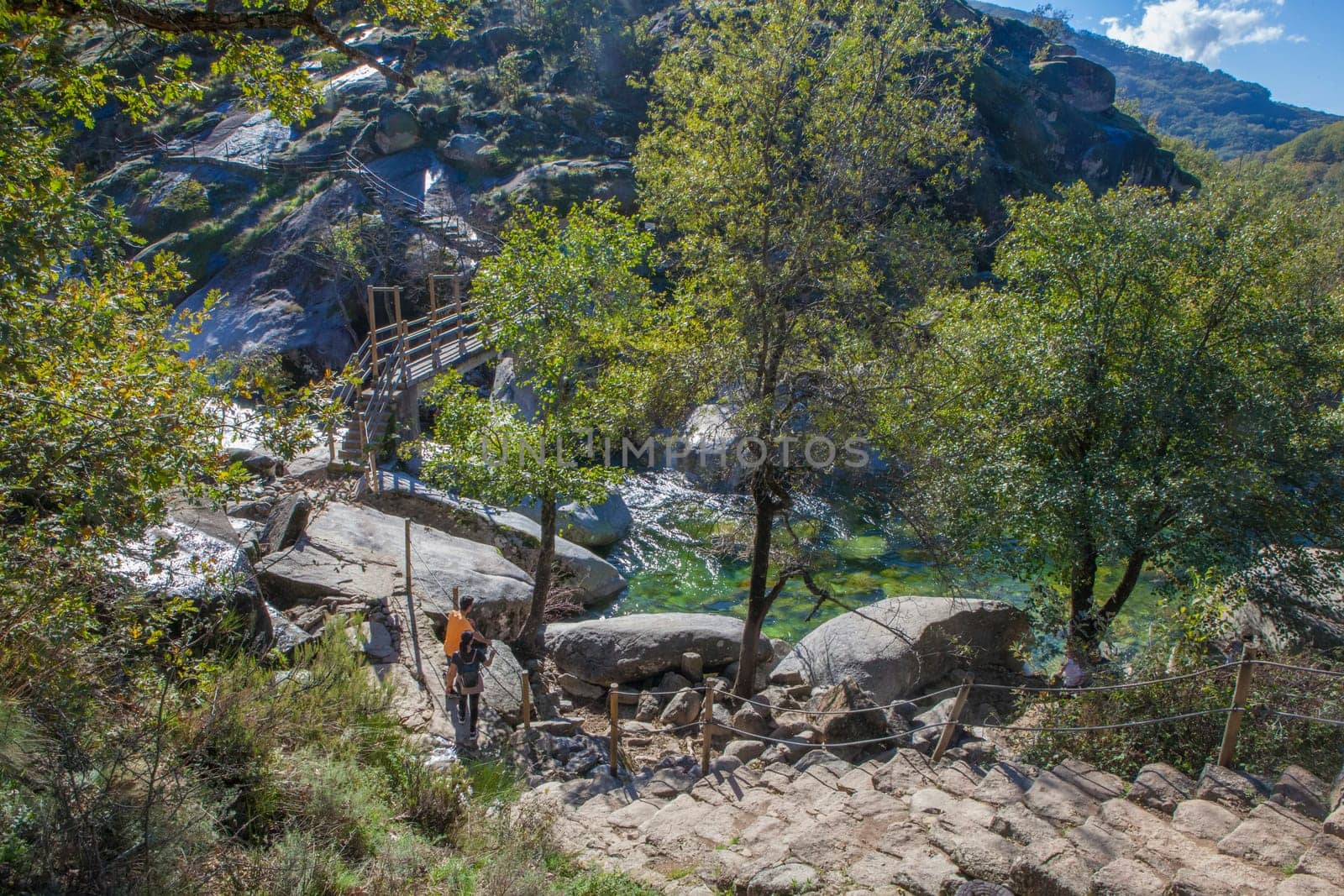 Trekkers about to cross the Los Pilones pedestrain bridge. Garganta de los Infiernos Reserve. Extremadura, Spain