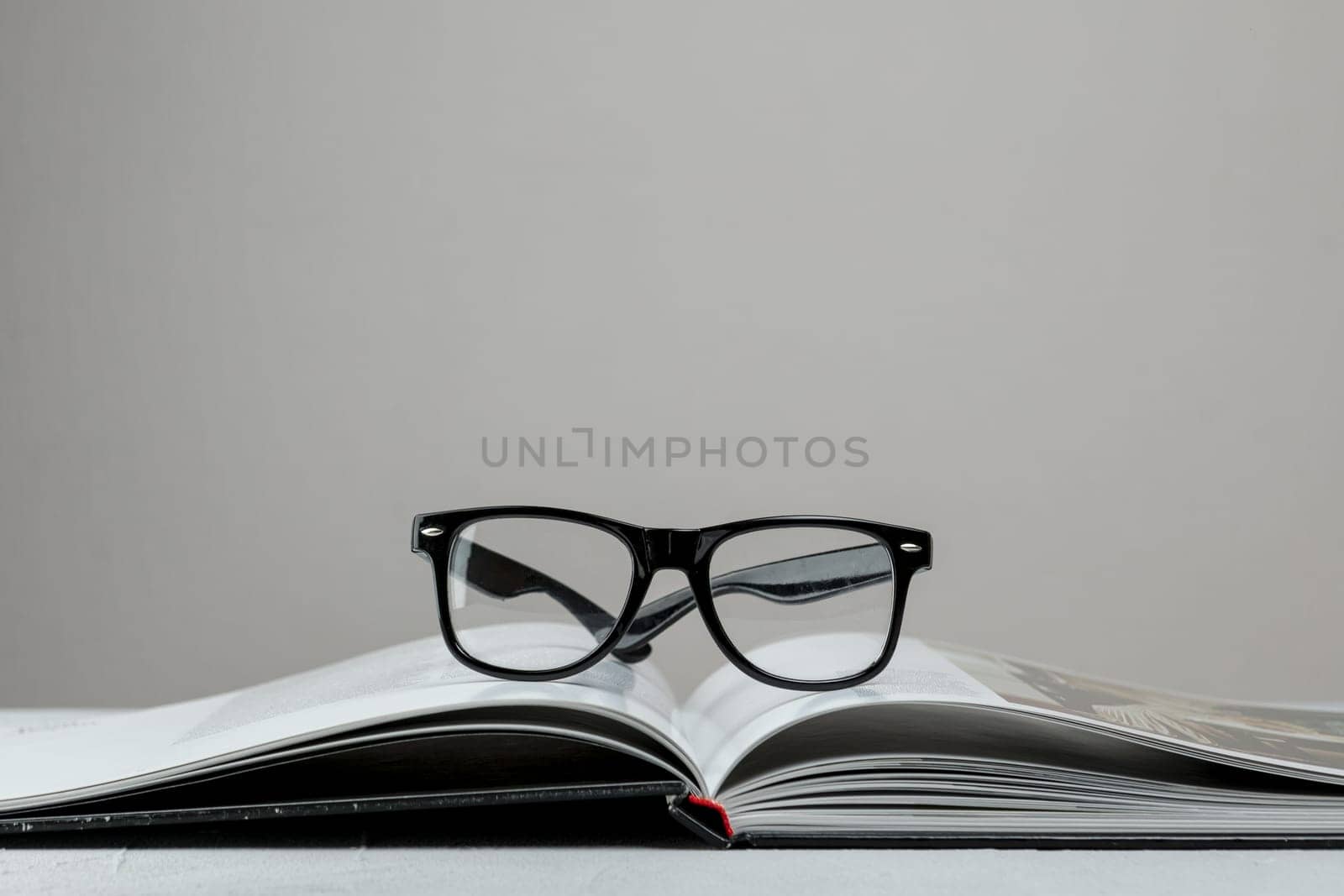front view open book with glasses