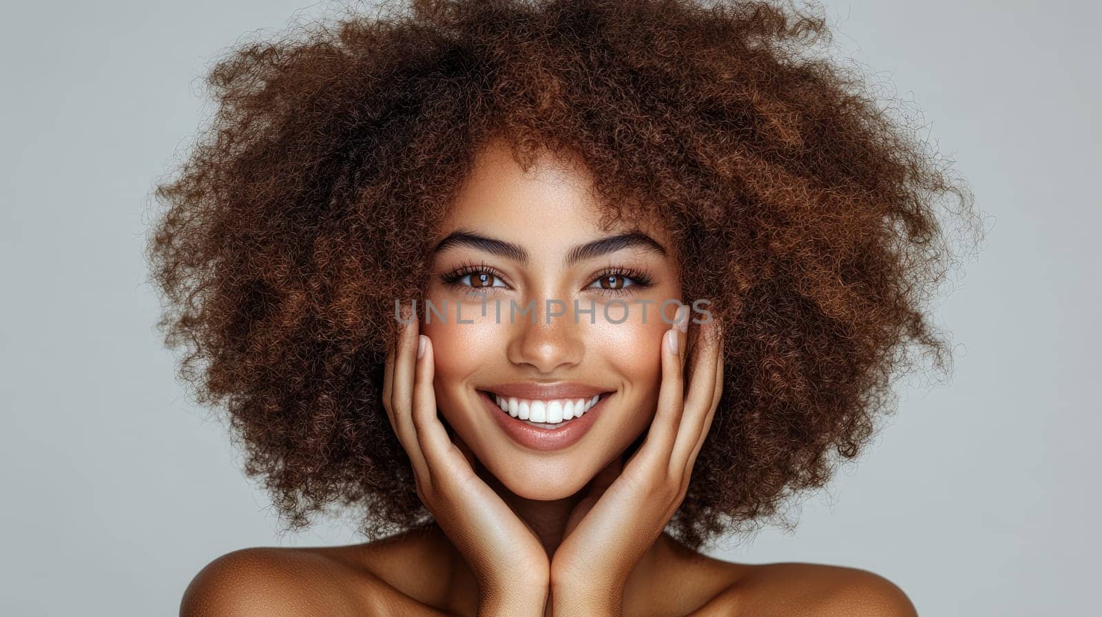 Portrait of a happy young woman with perfect smile and healthy skin is holding her face between her hands