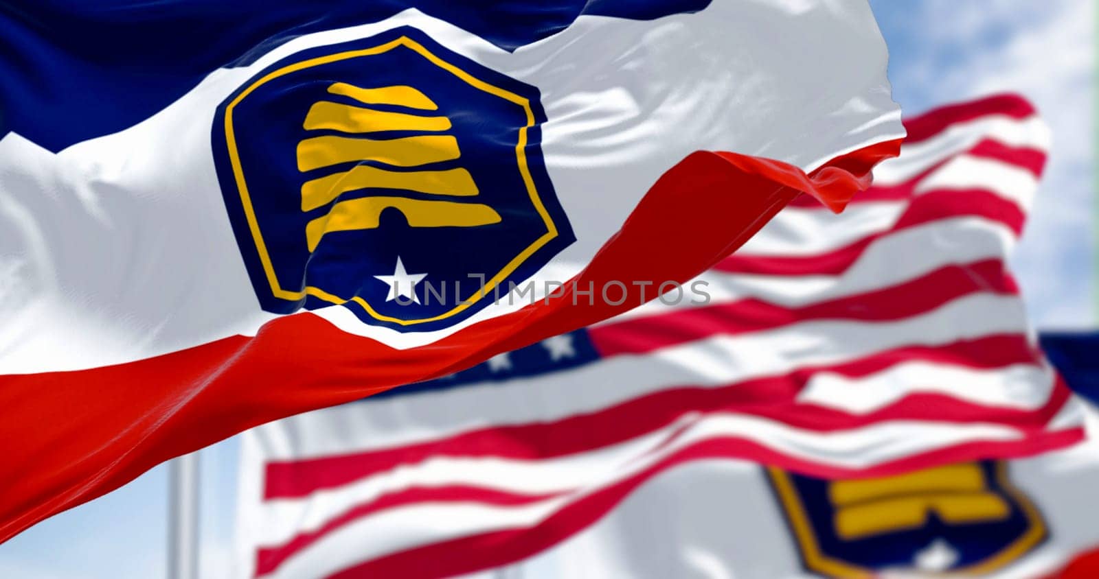 The Beehive Flag of Utah and the american flag waving on a clear day. 3D illustration render. Rippling fabric. Selective focus