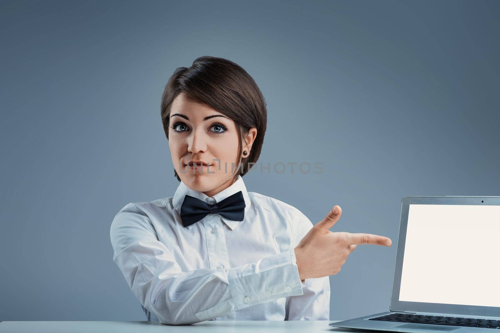 Confident young businesswoman presenting innovative ideas at desk with laptop, symbolizing growth and progress in career