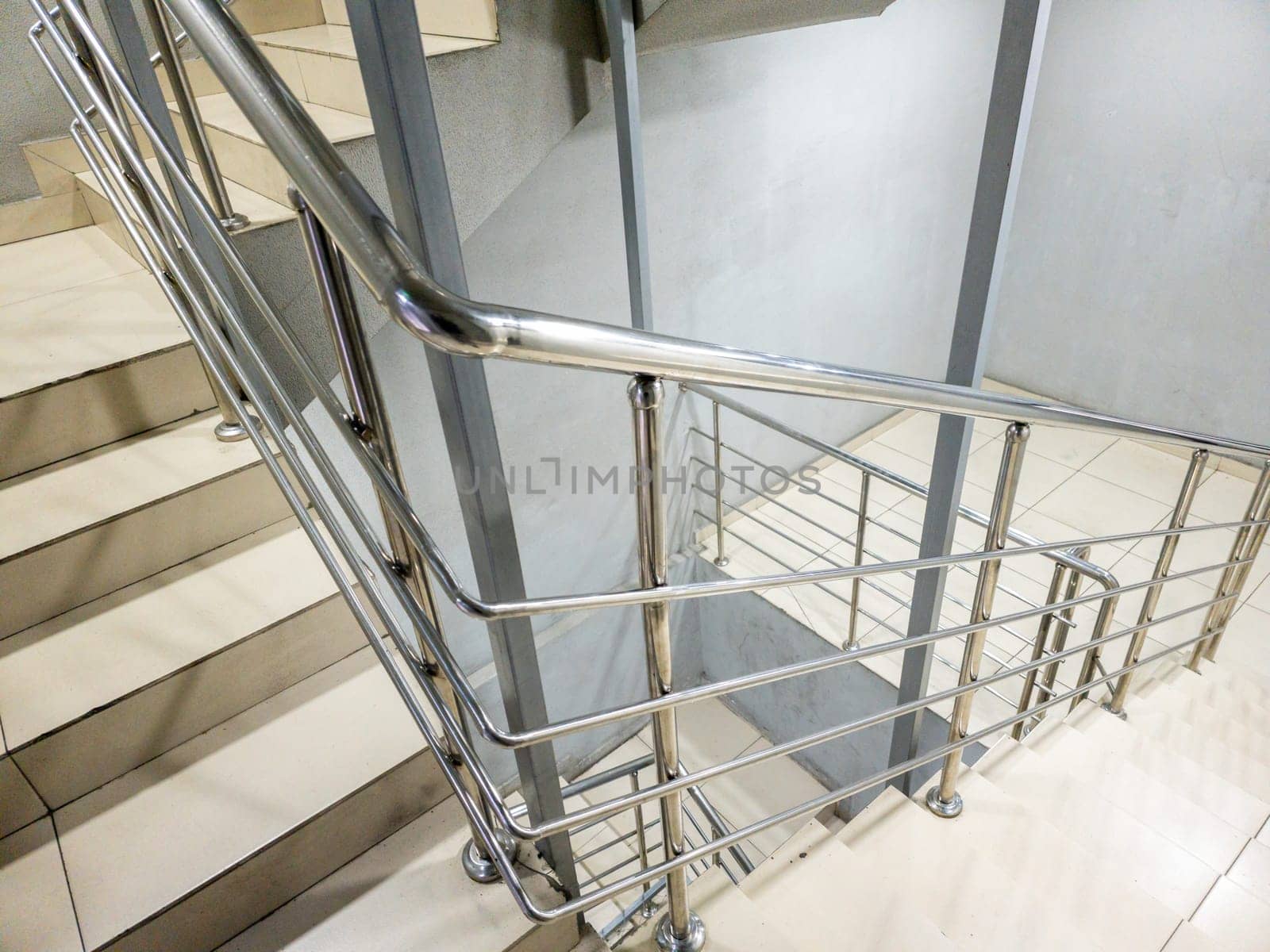 Generic modern staircase with a sleek stainless steel railing and minimalist design elements enhances its visual appeal