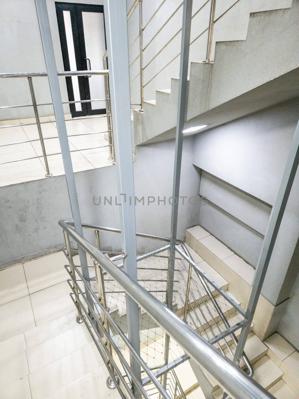 Generic modern staircase with a sleek stainless steel railing and minimalist design elements enhances its visual appeal
