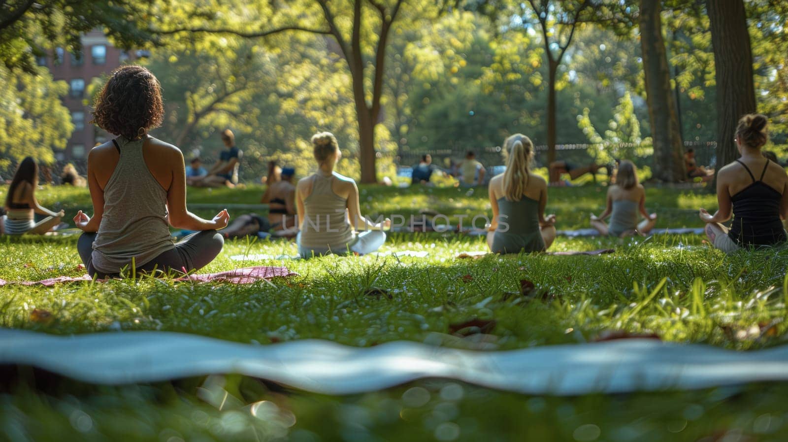 A group of people practice yoga in a serene park, surrounded by lush greenery under natural sunlight, creating a peaceful and mindful atmosphere.
