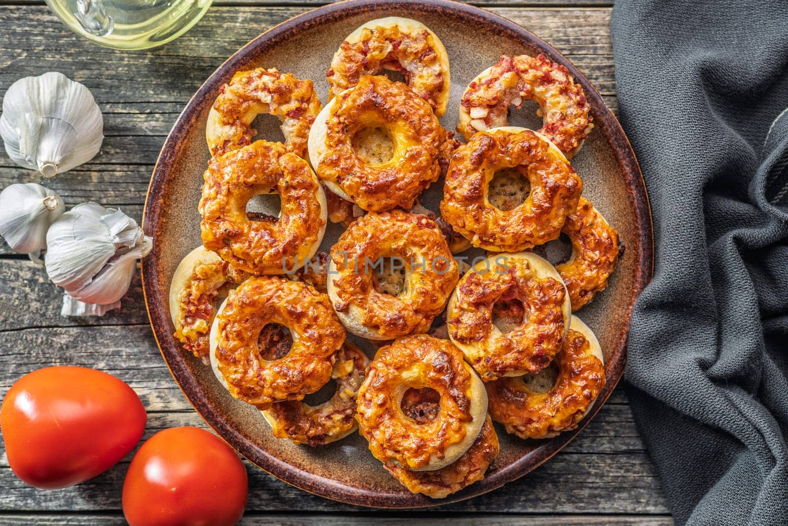 Mini pizza bagels on plate on a wooden table. Top view.
