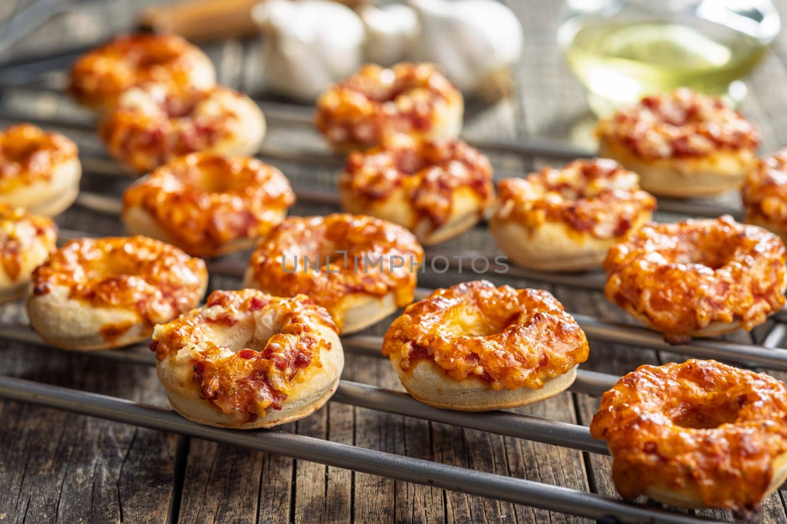 Mini pizza bagels on a wooden table.