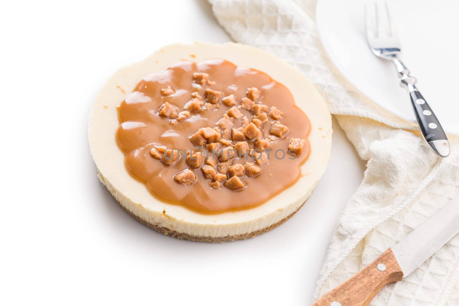 Cheesecake with caramel topping isolated on a white background.