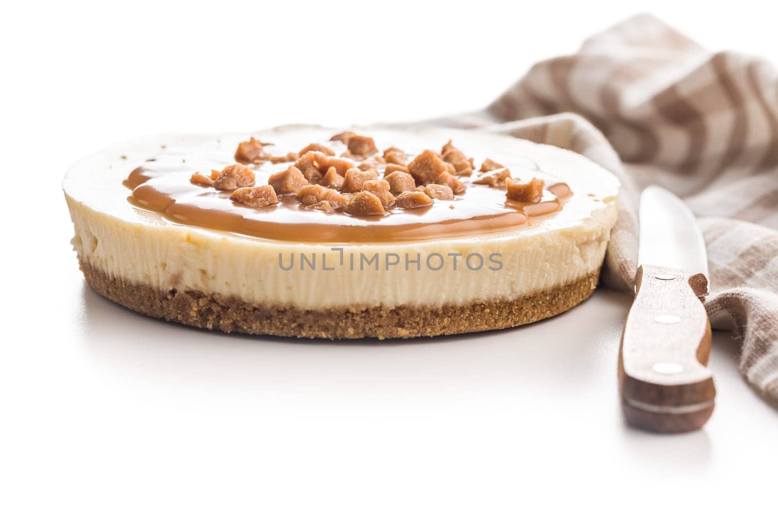 Cheesecake with caramel topping isolated on a white background.