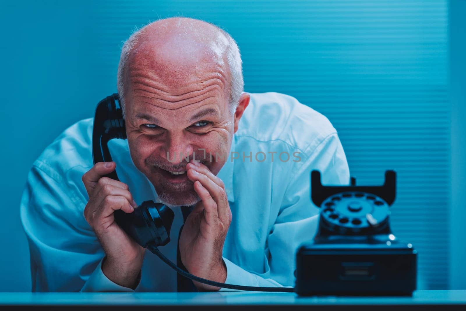 Sly mature businessman with blue eyes and a mischievous smile is whispering on a vintage telephone, clearly sharing some juicy gossip or confidential information