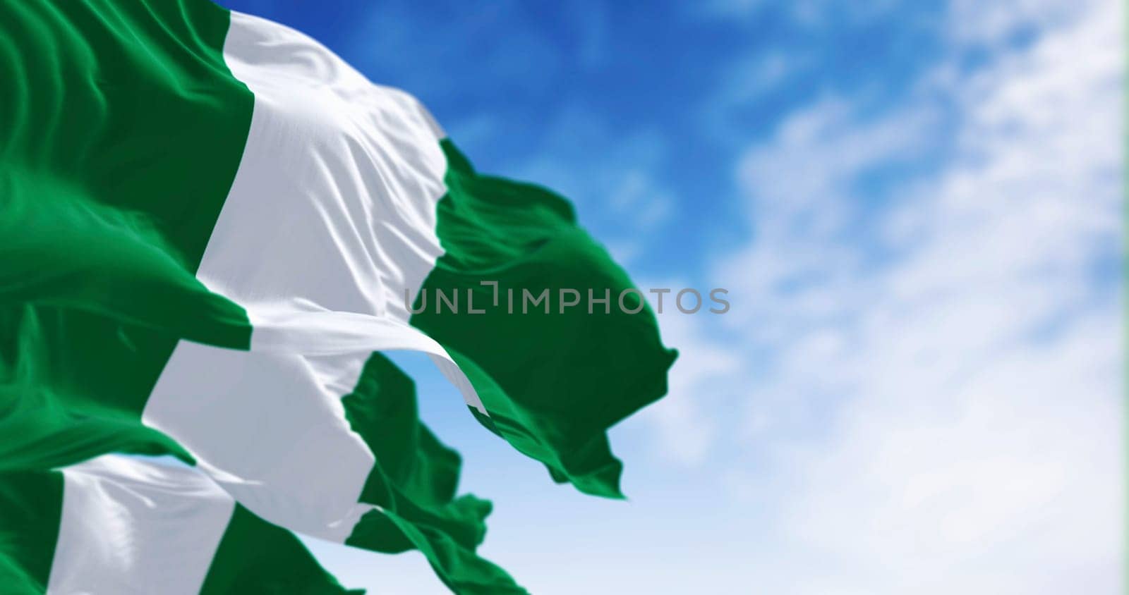 Nigeria national flags waving on a clear day. Three equal vertical bands: green, white and green. 3d illustration render. Selective focus. Close-up.