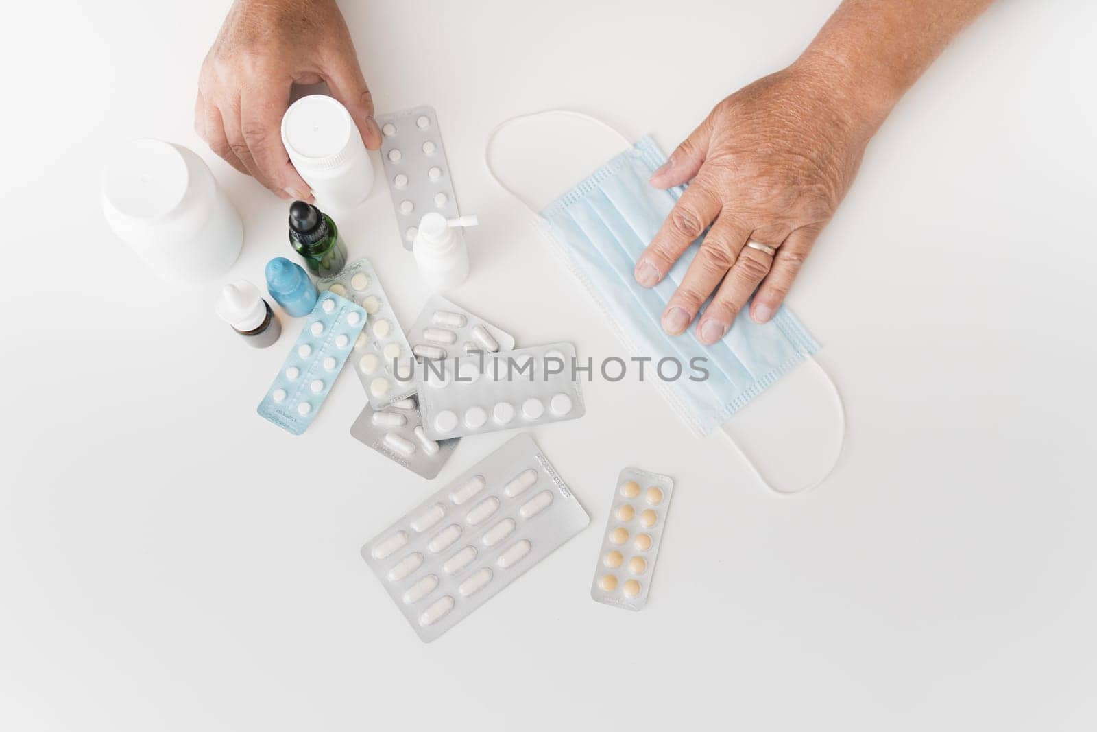 close up hands holding pills mask