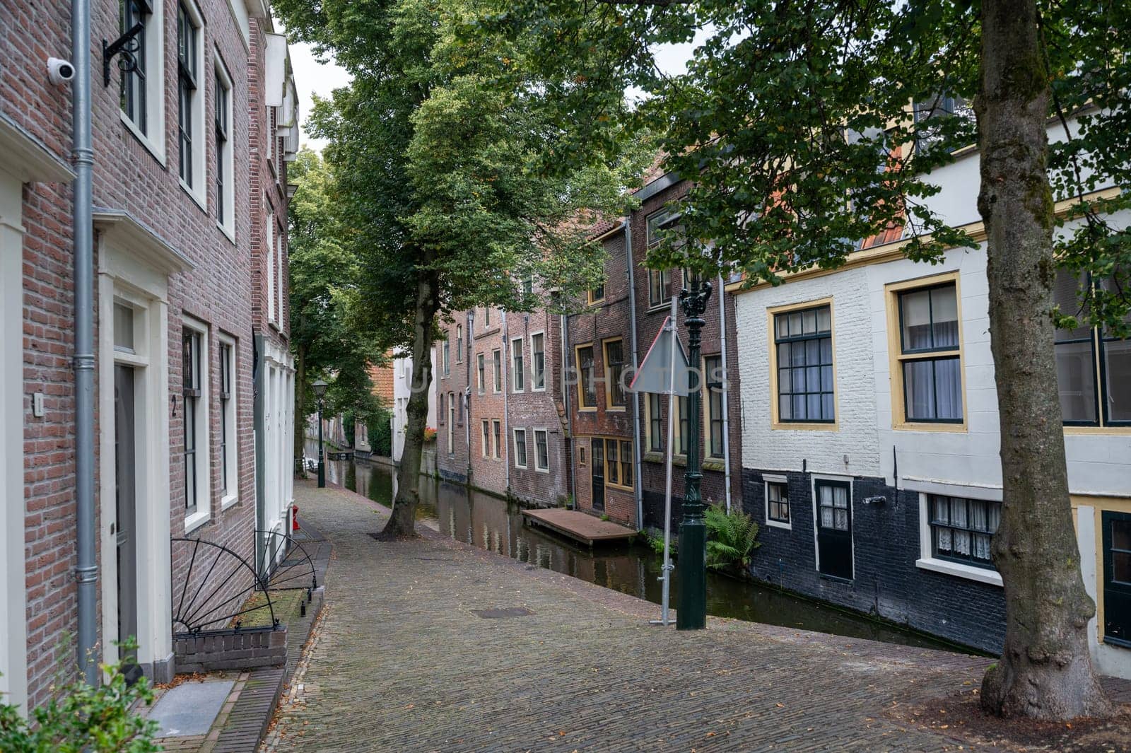 Houses on a water canal with a small street in the old town of Alkmaar in the Netherlands