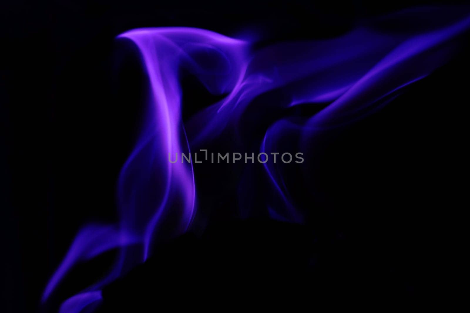Flames from a fire in blue against a black background