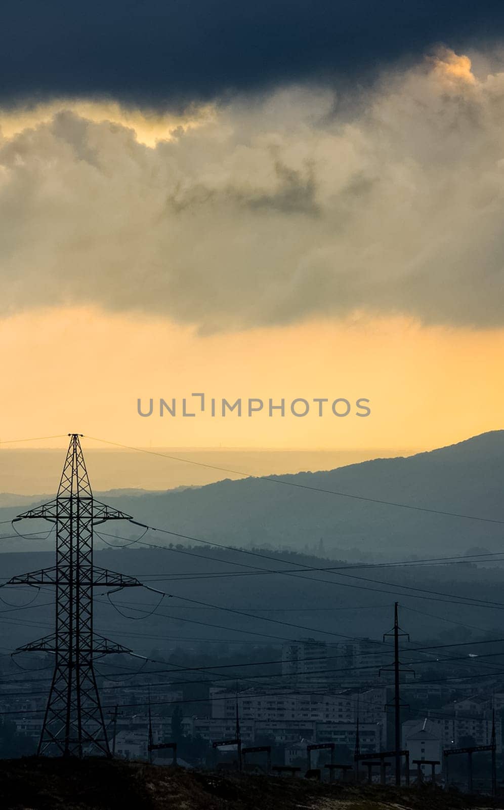 Dawn in the mountains of Crimea. A light haze of mist over the mountains and rays of the sun through the clouds.