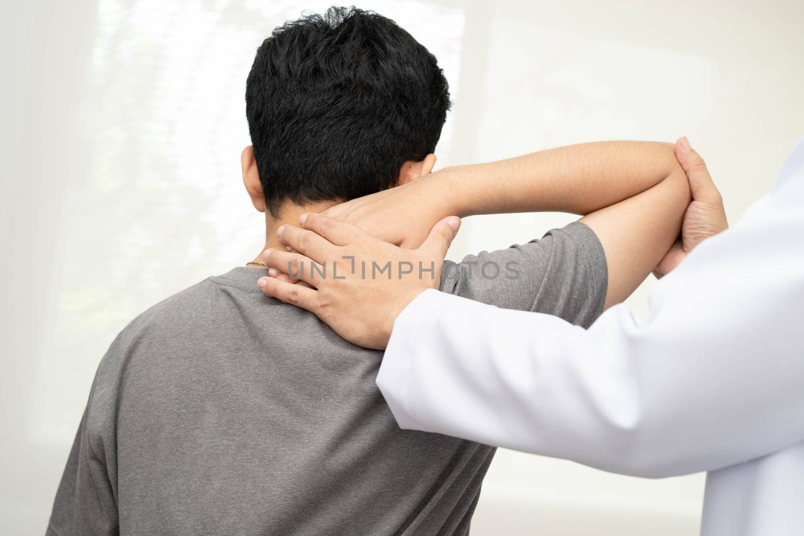 Physical therapy, Asian therapist doctor treat perform pain young man in hospital.