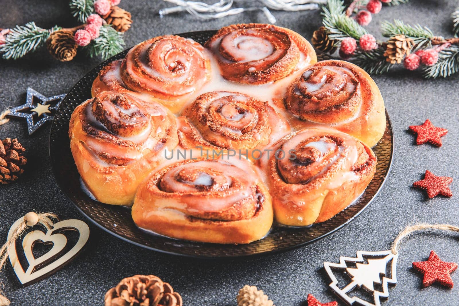 Cinnamon Rolls brioches or cinnamon rolls with icing sugar and cream cheese - decorated for Christmas in the studio