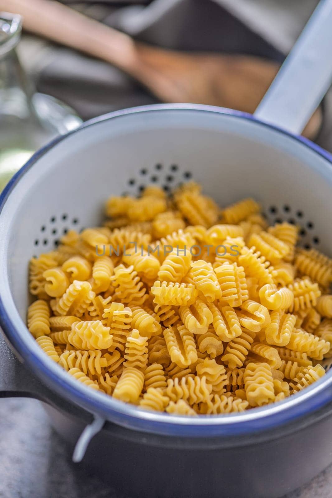 Uncooked italian pasta. Radiatori pasta in a colander.
