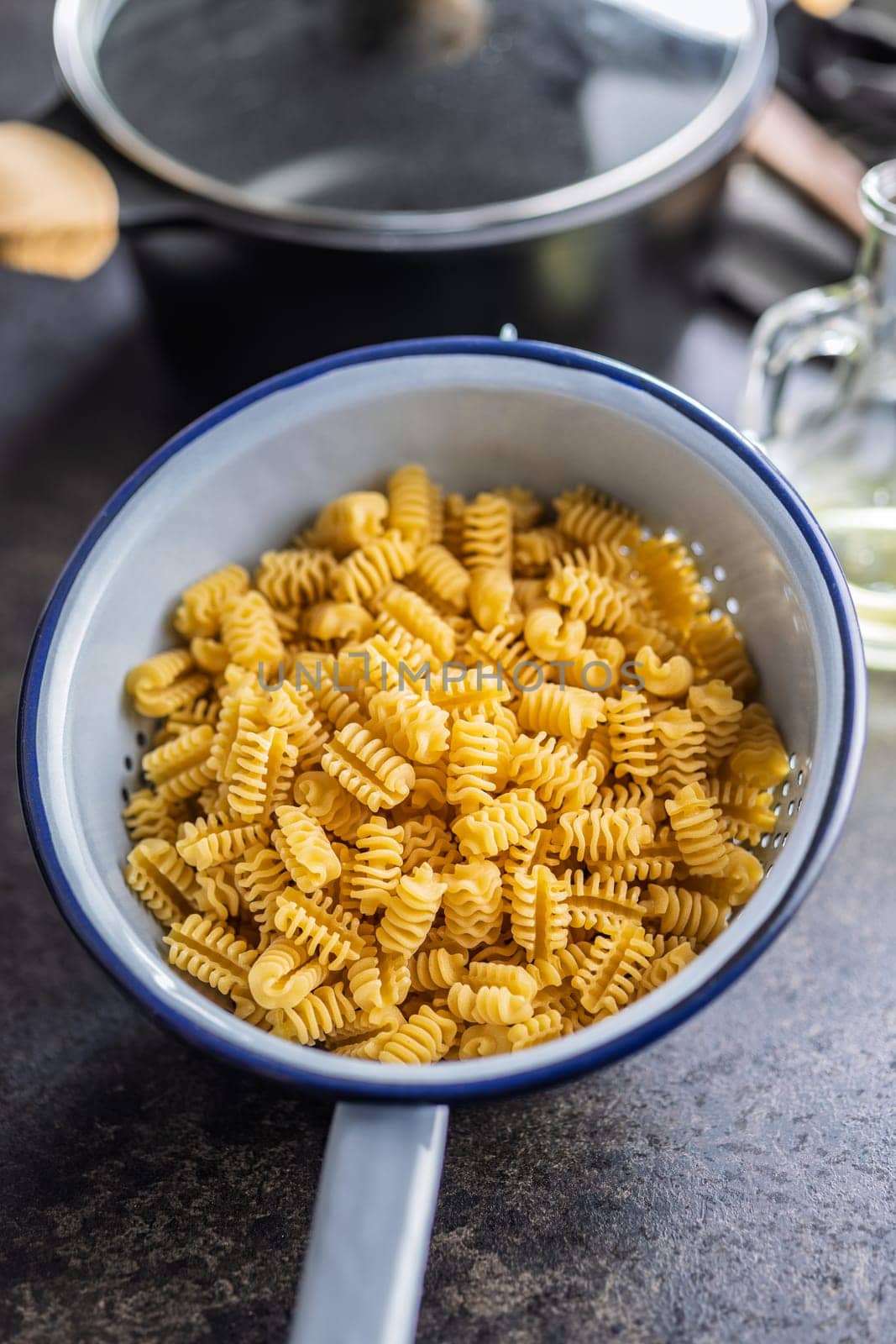 Uncooked italian pasta. Radiatori pasta in a colander.