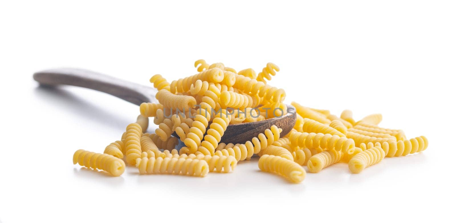 Uncooked italian pasta. Fusilli pasta on spoon isolated on a white background.