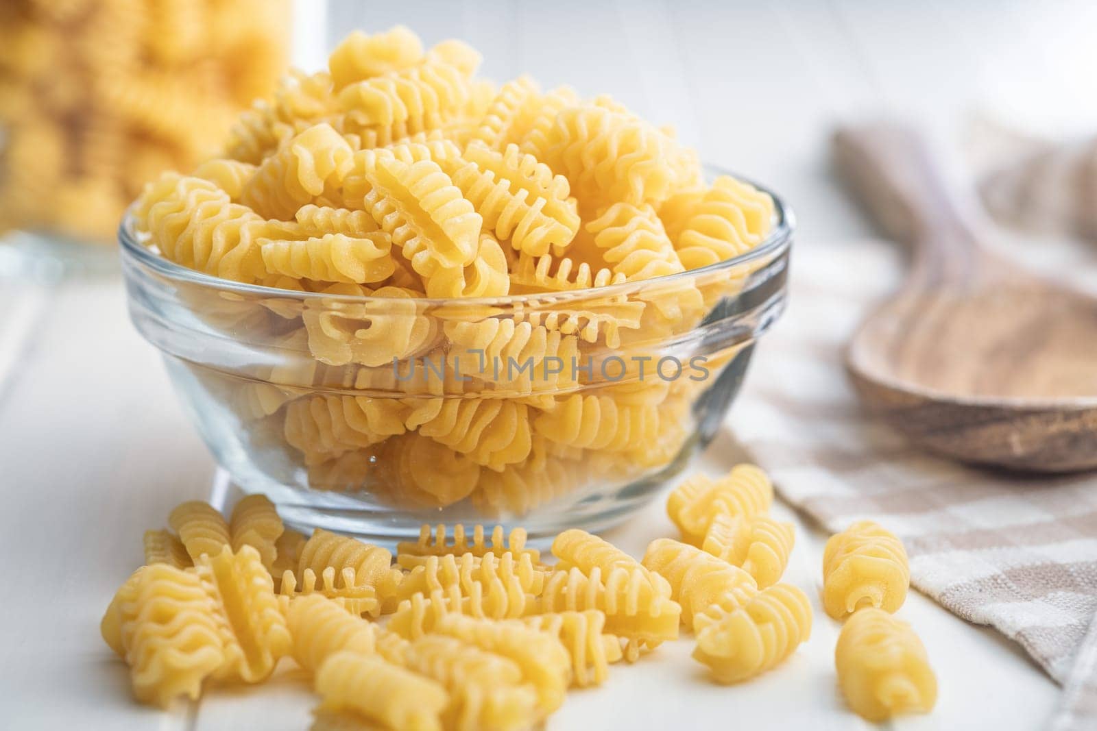 Uncooked italian pasta. Radiatori pasta in bowl on a white table.