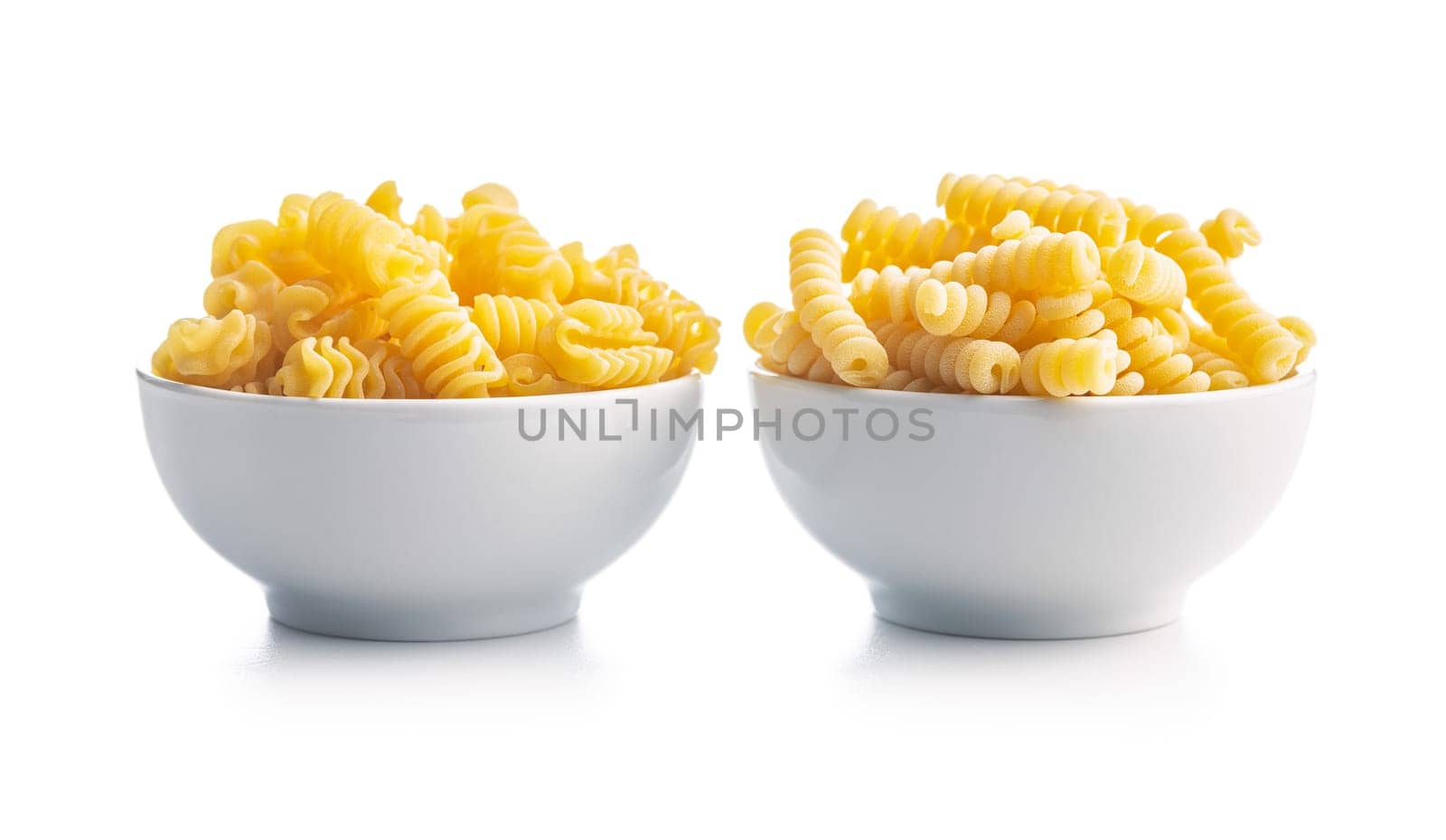 Uncooked italian pasta. Fusilli pasta in bowl isolated on a white background.