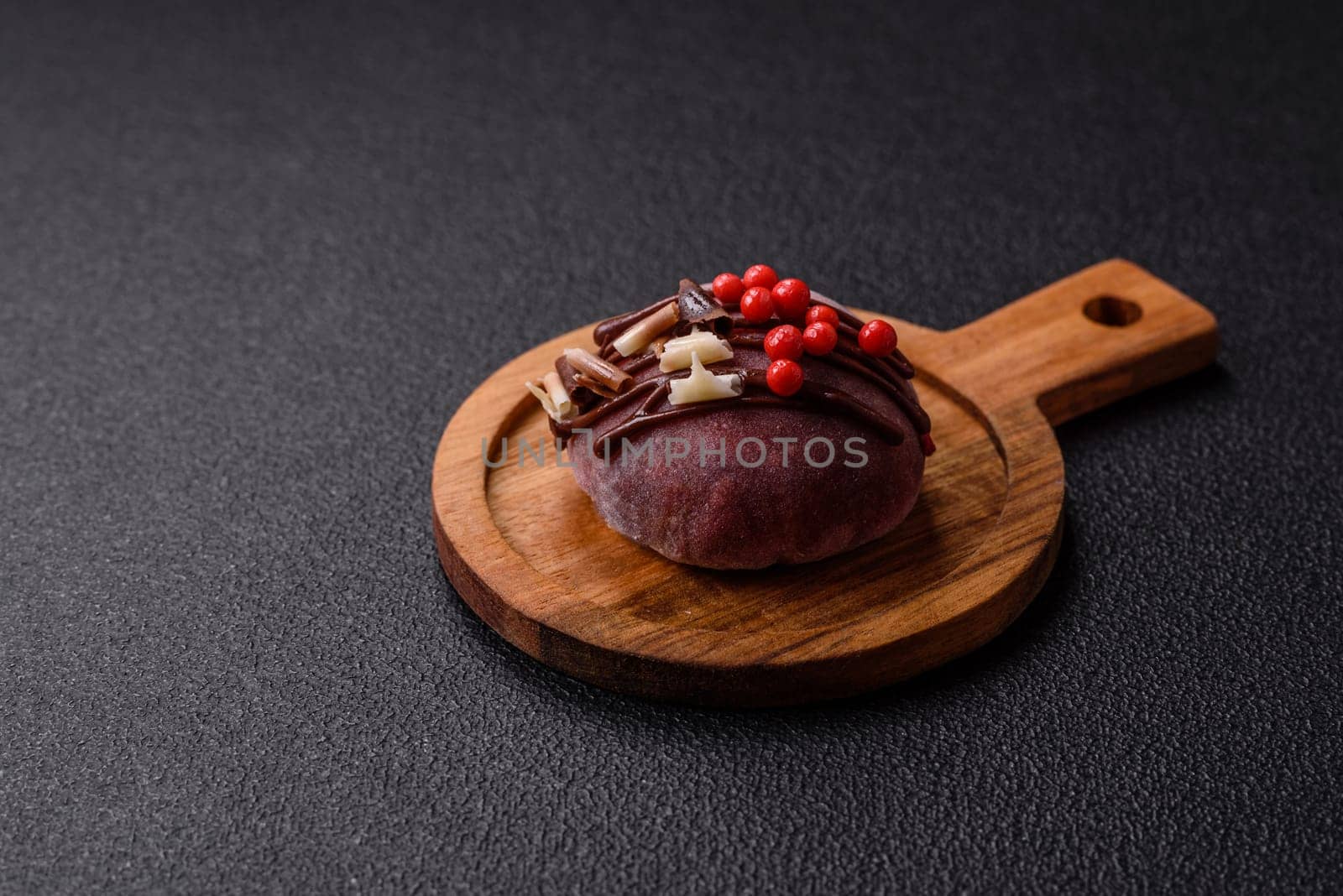 Delicious colorful asian mochi sweets with rice dough shell and fruit filling on dark concrete background